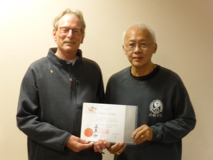 Philip Unger krijgt van zijn Chinese leraar Wee Kee Jin zijn diploma uitgereikt na het examen voor 'Instructor'